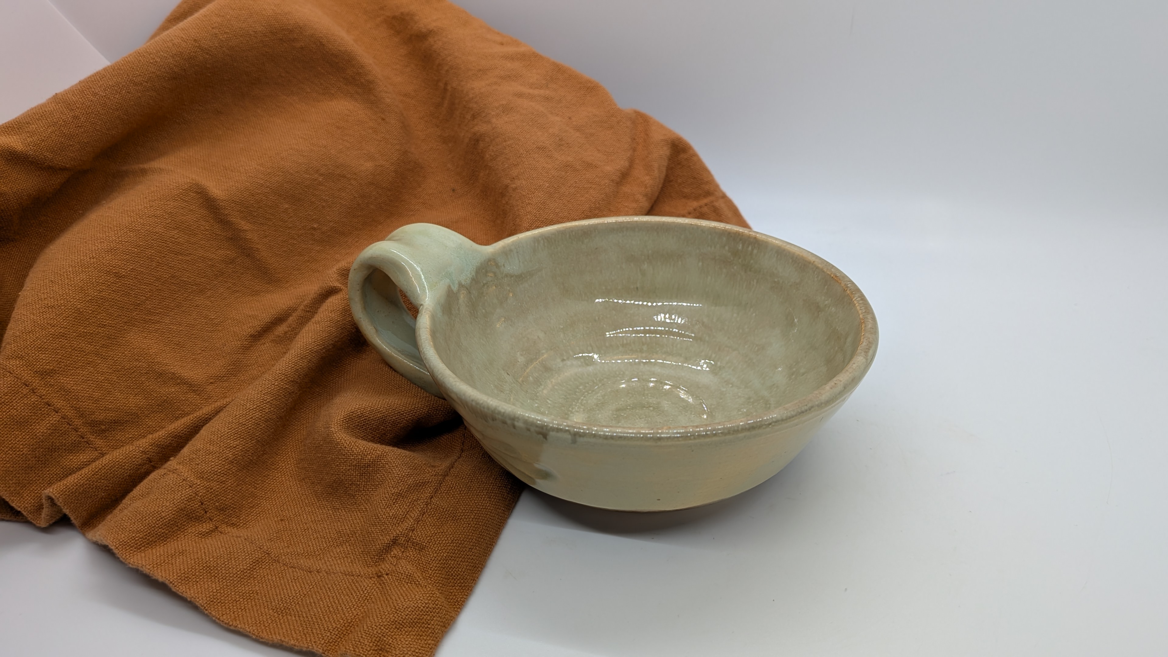 Flax Teacup - This was a test of a new-to-me glaze combination! I love how it came out... The exterior has a soft, creamy yellowish shade with hints of green, while the interior has an extra layer of color that softens the color a bit to a warm, flax-like tone. Subtle hand carving adds a simple, organic texture to the outside as well.

This is a lovely, lightweight teacup, and holds about 5 fluid ounces. - 25