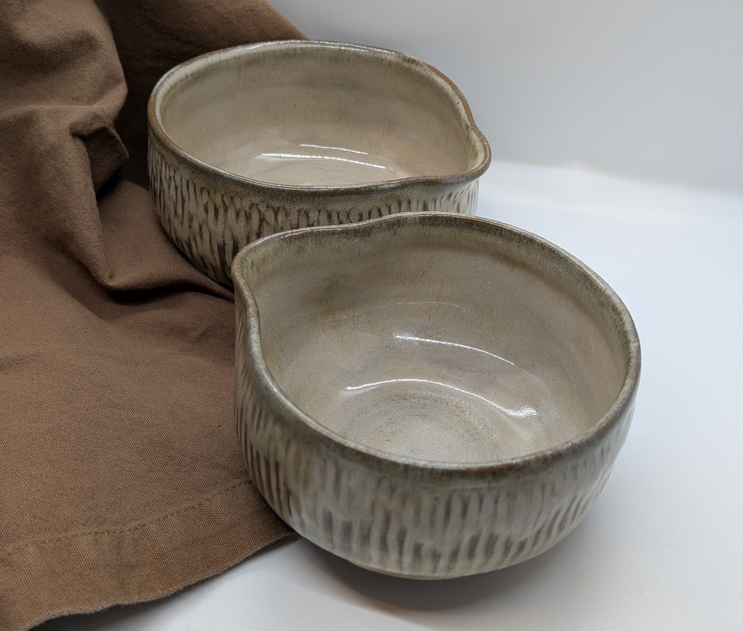 Cool Sepia Mini Mixers (Set of 2) - Landing in size between my popular nesting mini prep bowls, and a more typical batter bowl, these Mini Mixers are especially useful for small-batch baking. I love them because, as the only person in my family with some special-diet needs, they make it quick and easy to bake up small portions of my own treats. 

Use them to whip up just a few cookies, or simply for separating wet and dry ingredients, cracking eggs, and blending larger portions of salad dressings. Also great for eating soups, stews, rice dishes, and salads - the little spouts give your fork or spoon a perfect resting spot!

Sizes are approx. 4 1/2" and 5 1/2" wide by 3" tall, and they hold about 12 fl. oz. and 16 fl. oz. respectively. This set features hand-carved texture, making them easy to hold onto. 

 - 50